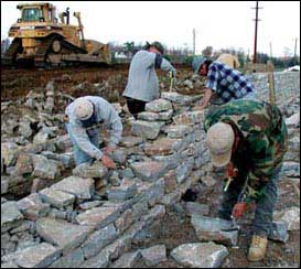 Construction crew building dry-stone masonry walls